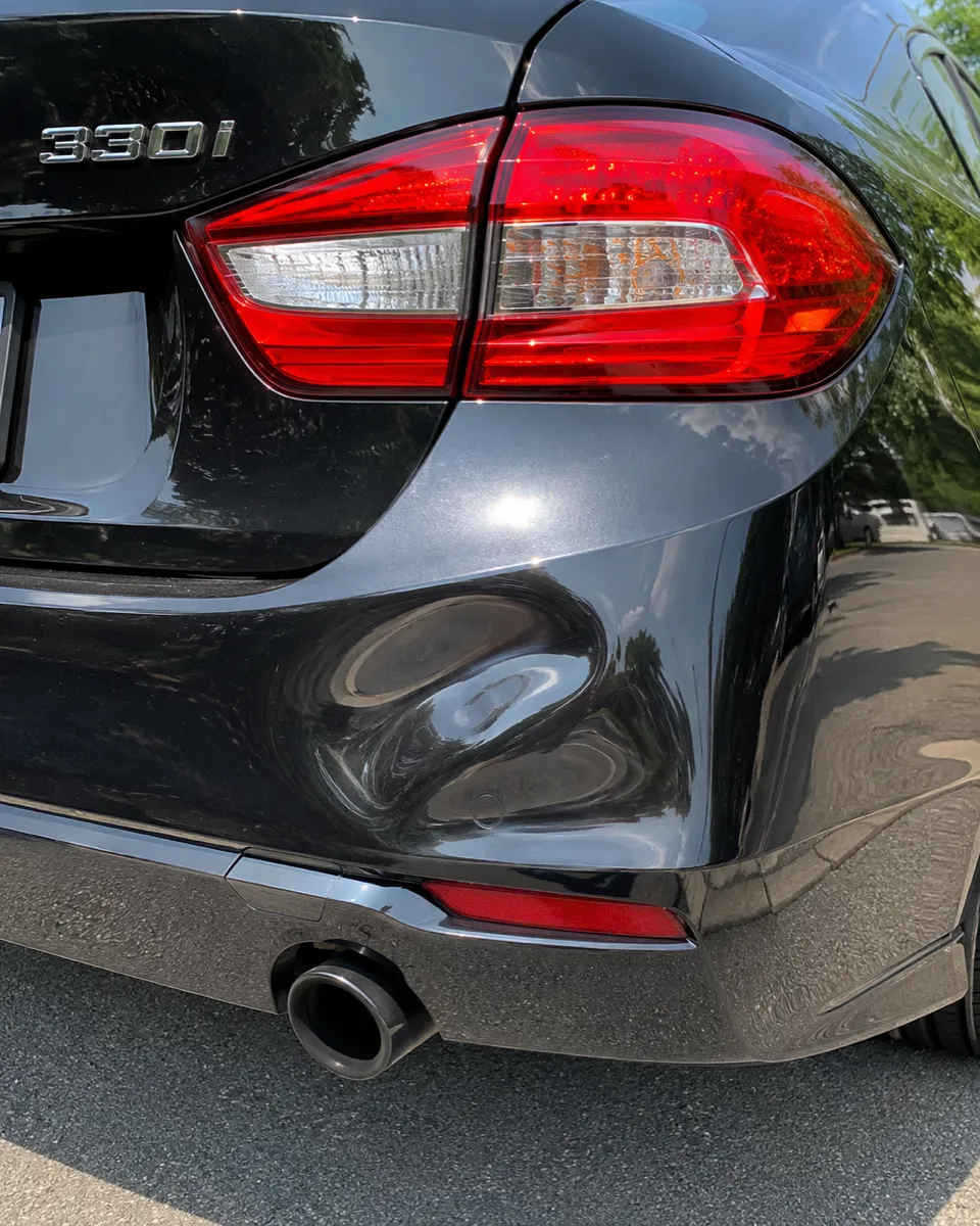 BMW 330i rear bumper dent repaired, original finish preserved in Mesa, AZ, before