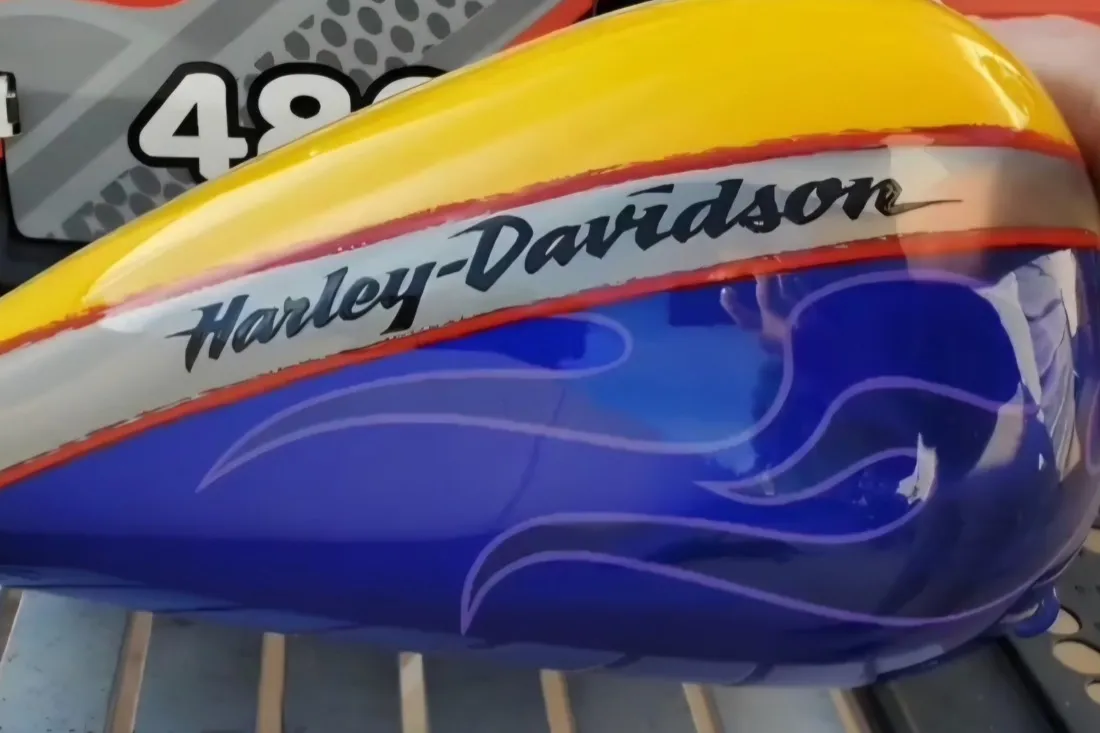 Custom flame Harley-Davidson fuel tank dent repaired with PDR, blue flame paint preserved in Mesa, AZ, after
