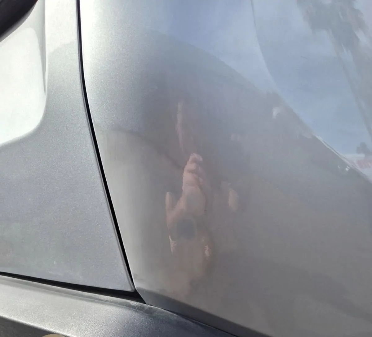 Large dent by the door seam removed with paintless dent repair in Mesa, AZ, after