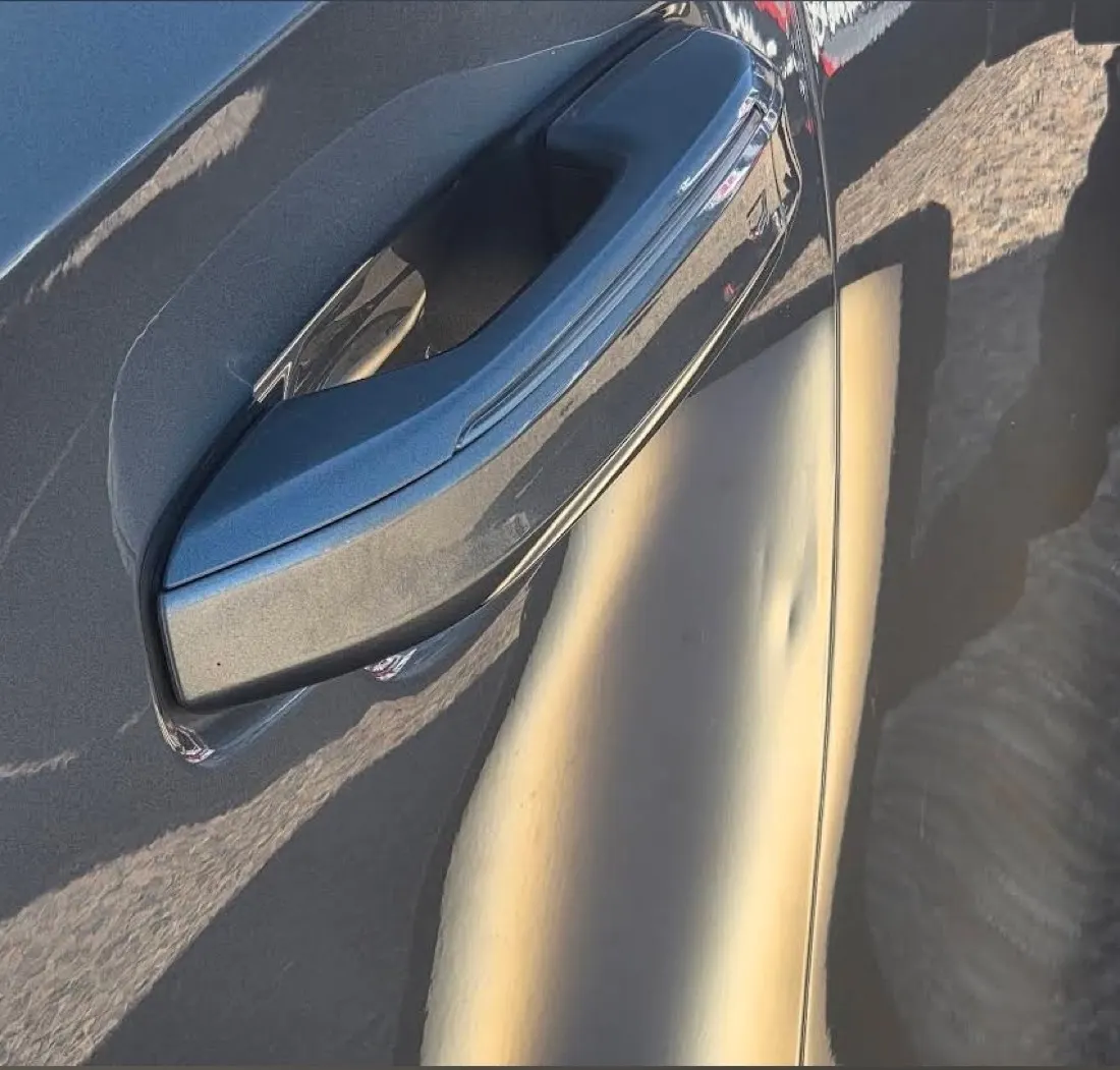 A door ding on a car panel before professional paintless dent repair