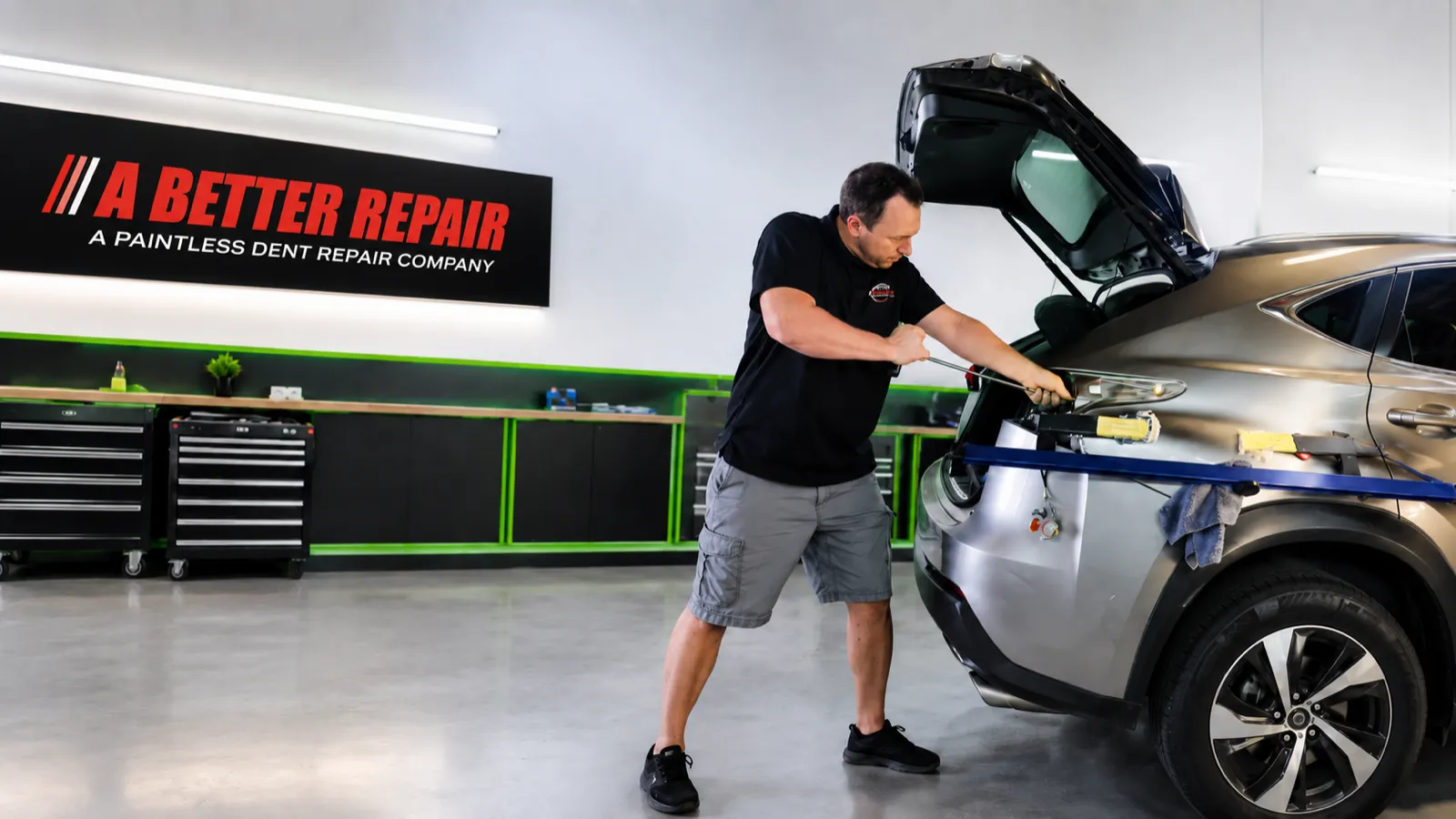 A paintless dent repair technician working a panel in the A Better Repair shop